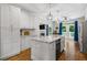 Bright kitchen features white cabinets, a marble island, stainless steel appliances, and access to the outdoor area at 1010 Longcreek Pointe, Alpharetta, GA 30005
