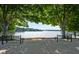 Scenic waterfront view with serene lake framed by lush green trees and a bench for relaxing at 1010 Longcreek Pointe, Alpharetta, GA 30005