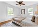 Bright bedroom featuring hardwood floors, two windows, a ceiling fan, and a cozy bed with decorative pillows at 1192 Willivee Dr, Decatur, GA 30033