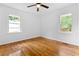Bright bedroom with hardwood floors, two windows, and a ceiling fan at 1192 Willivee Dr, Decatur, GA 30033