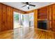 Cozy living room boasts hardwood floors, wood paneling, fireplace, and access to the outdoor deck at 1192 Willivee Dr, Decatur, GA 30033