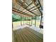 Enclosed back porch with a corrugated metal roof, wood posts, and wood plank flooring overlooks the backyard at 654 Continental Dr, Lawrenceville, GA 30044