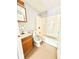 Bathroom with a single sink vanity, toilet, and a shower/tub combo with a cream colored tile surround at 654 Continental Dr, Lawrenceville, GA 30044