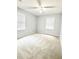 Spacious carpeted bedroom featuring two windows and a ceiling fan providing ample natural and artificial light at 654 Continental Dr, Lawrenceville, GA 30044