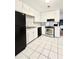 Functional kitchen with white cabinets, black appliances, tile floor, and stainless steel stove at 654 Continental Dr, Lawrenceville, GA 30044