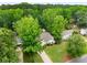 Aerial view of a charming home nestled among mature trees with a well-manicured lawn and inviting curb appeal at 7114 Surrey Pt, Alpharetta, GA 30009