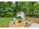 Gather around the fire pit in Adirondack chairs in the lush backyard with mature trees at 7114 Surrey Pt, Alpharetta, GA 30009