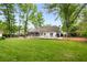 Lush backyard with a well-maintained lawn, a patio area, and mature trees at 7114 Surrey Pt, Alpharetta, GA 30009