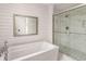 Modern bathroom with a soaking tub, tiled shower, and shiplap accent wall at 7114 Surrey Pt, Alpharetta, GA 30009