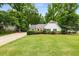 Well-manicured front yard of a charming one-story home with lush greenery at 7114 Surrey Pt, Alpharetta, GA 30009