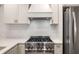 Close up of the stovetop and hood in this stainless steel kitchen at 7114 Surrey Pt, Alpharetta, GA 30009