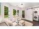 Functional laundry room with stackable washer and dryer, seating area, and outdoor access at 7114 Surrey Pt, Alpharetta, GA 30009