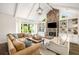 Bright living room featuring a stone fireplace, vaulted ceilings, and built-in shelving at 7114 Surrey Pt, Alpharetta, GA 30009