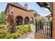 Landscaped backyard with brick patios, arched doorways, lush greenery, and mature trees offers tranquility and privacy at 210 4Th St, Fayetteville, GA 30214