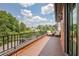 Spacious balcony with chairs, brick railing and serene treetop views, offering outdoor relaxation and enjoyment at 210 4Th St, Fayetteville, GA 30214