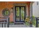 Welcoming front door with a round window, brick facade, and stylish planters on a stone porch at 210 4Th St, Fayetteville, GA 30214