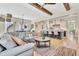 Open-concept living room with exposed wood beams, hardwood floors, and a seamless transition to the kitchen at 210 4Th St, Fayetteville, GA 30214