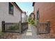 Side yard with a charming wooden gate, gravel path, and landscaped greenery creates a private outdoor space at 210 4Th St, Fayetteville, GA 30214