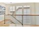 Elegant staircase with wood and iron railing, offering a view through large windows at 210 4Th St, Fayetteville, GA 30214