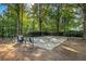 Basketball court with benches and trash can surrounded by trees and black chain link fence at 325 Meadows Ln, Canton, GA 30114