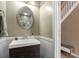 Modern bathroom features a dark vanity with white sink and decorative mirror at 325 Meadows Ln, Canton, GA 30114