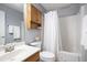 Traditional bathroom with white shower curtain, wood vanity, and functional storage cabinet at 325 Meadows Ln, Canton, GA 30114