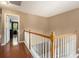 Second floor hallway with wood floors, stairs, and access to the bedrooms at 325 Meadows Ln, Canton, GA 30114