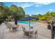 Relaxing community pool area with lounge chairs and tables under umbrellas, offering ample seating at 325 Meadows Ln, Canton, GA 30114
