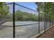 Fenced in tennis court surrounded by trees at 325 Meadows Ln, Canton, GA 30114
