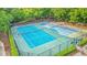 Aerial view of newly resurfaced tennis courts surrounded by trees and well manicured landscape at 325 Meadows Ln, Canton, GA 30114