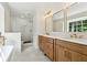 Modern bathroom with double vanity, frameless shower, soaking tub, and gold fixtures at 5631 Queensborough Dr, Atlanta, GA 30338