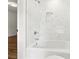 Bright bathroom featuring stylish white marble tile, shower head, and bathtub at 5631 Queensborough Dr, Atlanta, GA 30338