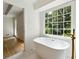 Soaking tub with views to the outside. Bathroom with a frameless glass shower at 5631 Queensborough Dr, Atlanta, GA 30338