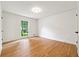 A bright room with a window and hardwood flooring is freshly painted and ready for your personalization at 5631 Queensborough Dr, Atlanta, GA 30338