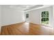 A light-filled bedroom with hardwood floors and large windows overlooking the lush greenery at 5631 Queensborough Dr, Atlanta, GA 30338