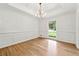 Light-filled dining room with gleaming hardwood floors, wainscoting and chandelier at 5631 Queensborough Dr, Atlanta, GA 30338
