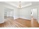 Spacious room with hardwood flooring, wainscoting and access to other rooms at 5631 Queensborough Dr, Atlanta, GA 30338