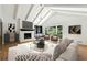 Bright living room featuring vaulted ceilings, a brick fireplace, and large windows offering scenic views at 5631 Queensborough Dr, Atlanta, GA 30338