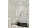 An updated tiled walk-in shower features frameless glass door and black herringbone floor at 5631 Queensborough Dr, Atlanta, GA 30338