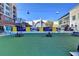 Scenic view of the Town Green with its synthetic grass, benches, restaurants, and event stage under a clear blue sky at 785 Cirrus Dr, Johns Creek, GA 30022