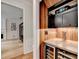 Elegant wine bar featuring wooden accents, wine storage, and a countertop, adjacent to the entryway at 785 Cirrus Dr, Johns Creek, GA 30022