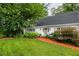 Well-maintained home with green lawn, manicured bushes, and classic architectural details under a canopy of mature trees at 956 Clifton Ne Rd, Atlanta, GA 30307