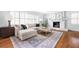 Open-concept room with fireplace, hardwood floors, a sectional sofa, and ample natural light at 956 Clifton Ne Rd, Atlanta, GA 30307