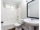 Bathroom featuring a tub-shower combo and pedestal sink at 1916 Highway 138 Sw, Conyers, GA 30094
