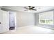 Neutral bedroom with a ceiling fan, large window, carpet, and white trim at 1916 Highway 138 Sw, Conyers, GA 30094