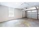 Spacious garage with roll up door, painted walls, and a window provides ample parking and storage solutions at 1916 Highway 138 Sw, Conyers, GA 30094