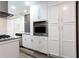 Modern kitchen features stainless steel oven, grey backsplash, granite countertops, white cabinets, and hardwood floors at 1916 Highway 138 Sw, Conyers, GA 30094