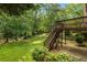 Picturesque backyard with wooden deck and stairs leading to a lush, green lawn and mature trees at 3570 Bardfield Ct, Cumming, GA 30041