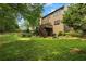 Spacious backyard features a wooden deck with stairs and mature landscaping; barbecue on the patio below at 3570 Bardfield Ct, Cumming, GA 30041