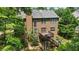 This exterior view of a two-story home features a back deck, lush greenery, and a grill at 3570 Bardfield Ct, Cumming, GA 30041